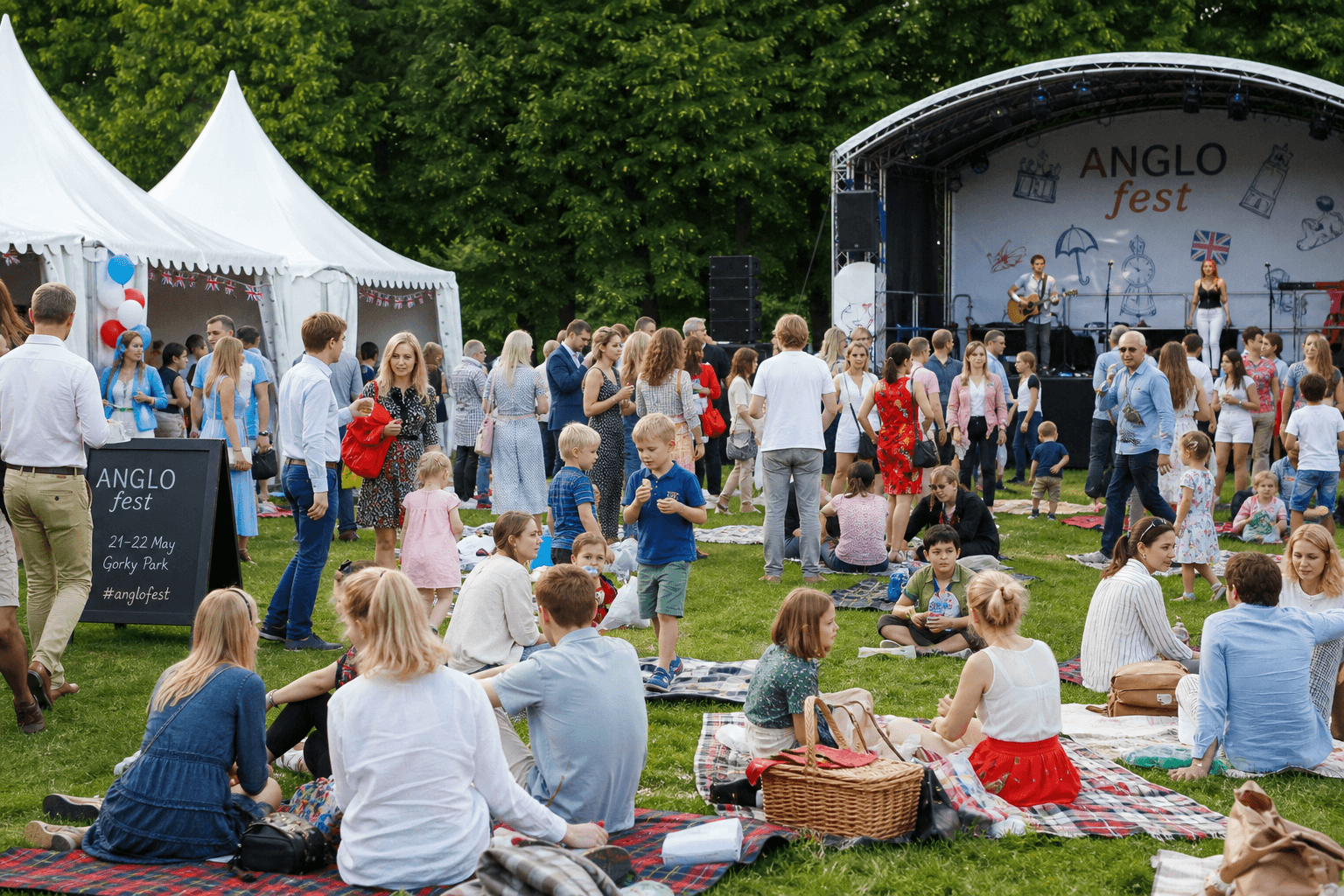 Families gathered on the grass between festival tents and a stage